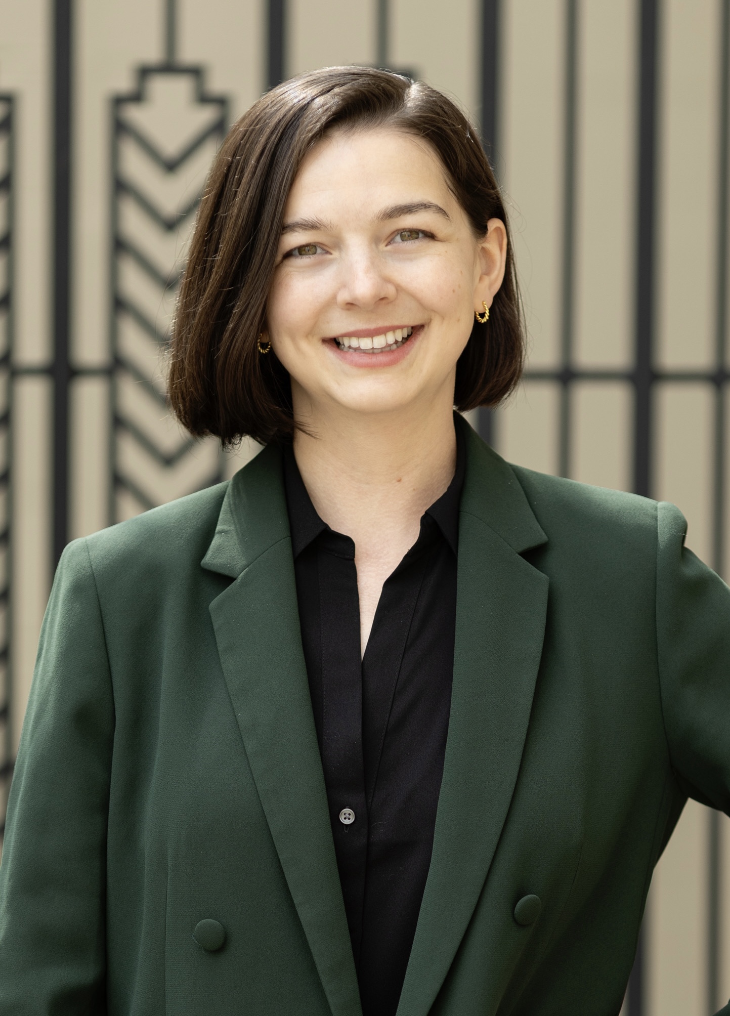 Headshot of Dr. Rachel E. Dubit smiling and wearing a green suit
